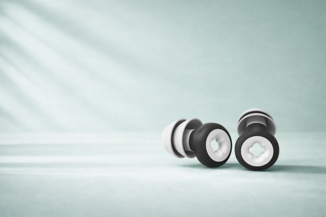 Pair of black and white ear plugs on a light gray background