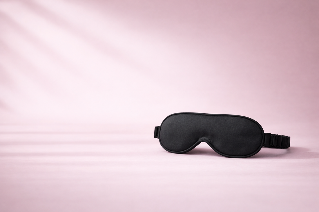 Black sleep mask on a pink background